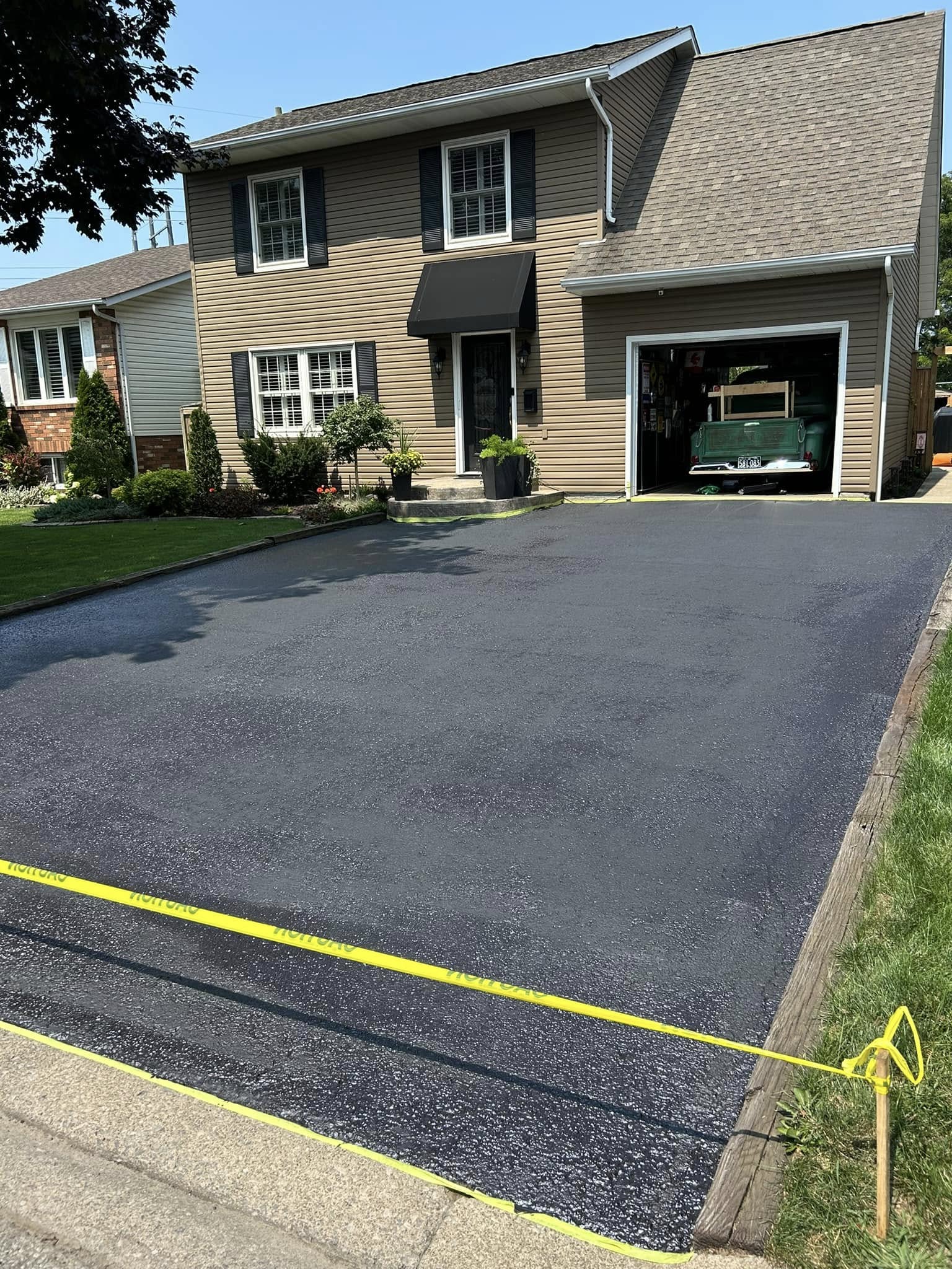 Close-up of asphalt driveway being sealcoated